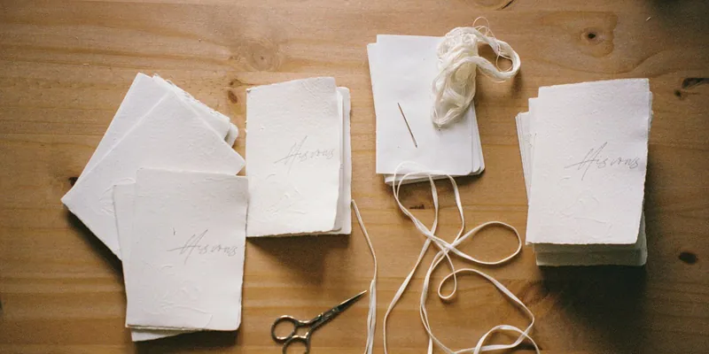 Papier, Schere und Band zum Geschenkverpacken als Flatlay auf Holz